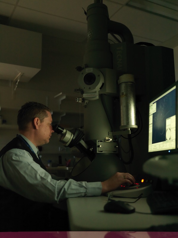 Dr Roberts working on the electron microscope in the laboratory.